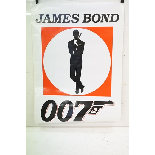 399 - Set of five James Bond photographs, signed, 56 x 60cm overall, James Bond 007 poster, gun symbol log... 