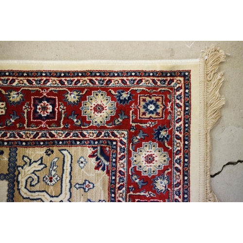 574 - Ivory ground Kashmir floor rug with Aztec medallion design, approx 180cm long x 116cm wide