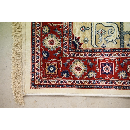 574 - Ivory ground Kashmir floor rug with Aztec medallion design, approx 180cm long x 116cm wide