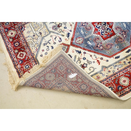 574 - Ivory ground Kashmir floor rug with Aztec medallion design, approx 180cm long x 116cm wide