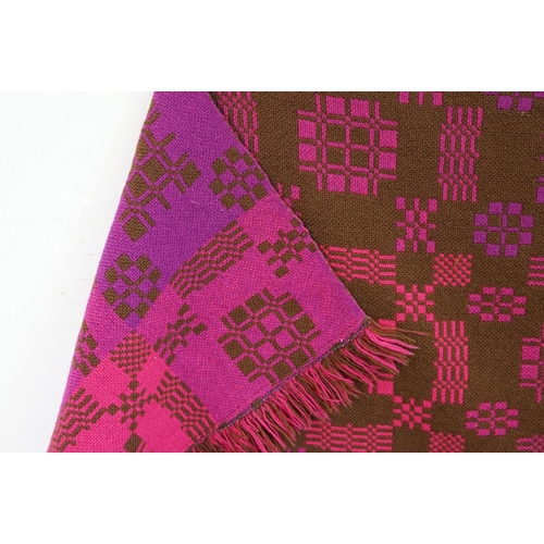 415 - Welsh woollen blanket, of arch shaped form, geometric pink and purple designs on a brown ground, wit... 