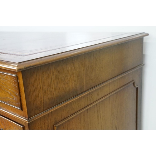 530 - Oak twin pedestal desk, with red leather inset top and an arrangement of nine drawers, with key, 79c... 