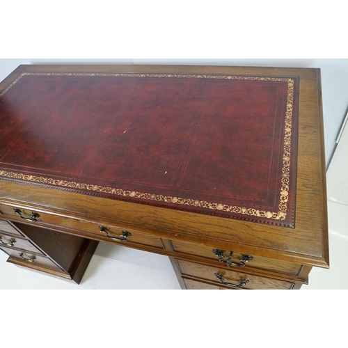 530 - Oak twin pedestal desk, with red leather inset top and an arrangement of nine drawers, with key, 79c... 