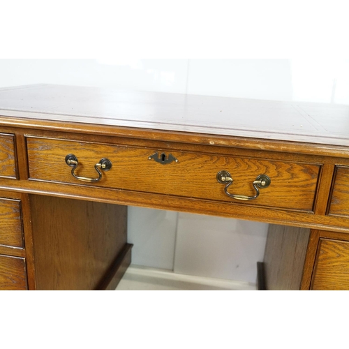 530 - Oak twin pedestal desk, with red leather inset top and an arrangement of nine drawers, with key, 79c... 