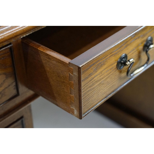 530 - Oak twin pedestal desk, with red leather inset top and an arrangement of nine drawers, with key, 79c... 