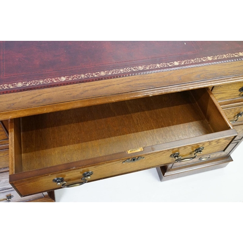 530 - Oak twin pedestal desk, with red leather inset top and an arrangement of nine drawers, with key, 79c... 