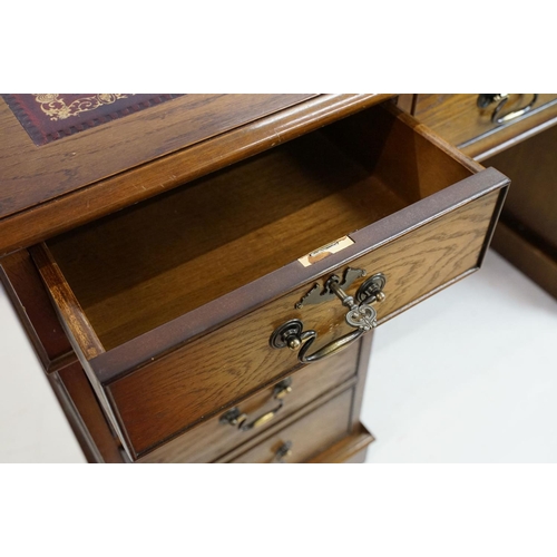 530 - Oak twin pedestal desk, with red leather inset top and an arrangement of nine drawers, with key, 79c... 