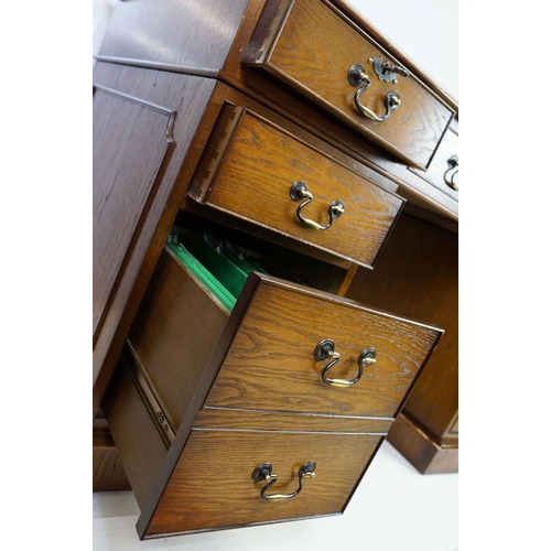 530 - Oak twin pedestal desk, with red leather inset top and an arrangement of nine drawers, with key, 79c... 