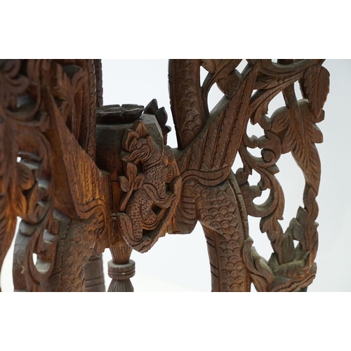 532 - Indian carved hardwood occasional table, the top carved with a central panel depicting three figures... 