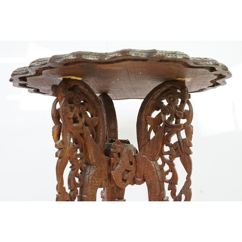 532 - Indian carved hardwood occasional table, the top carved with a central panel depicting three figures... 