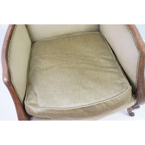 522 - Early 20th century low armchair with oak frame, upholstered in beige with studded edging, on cabriol... 