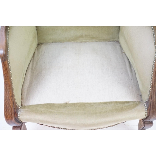 522 - Early 20th century low armchair with oak frame, upholstered in beige with studded edging, on cabriol... 