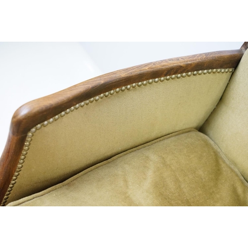 522 - Early 20th century low armchair with oak frame, upholstered in beige with studded edging, on cabriol... 