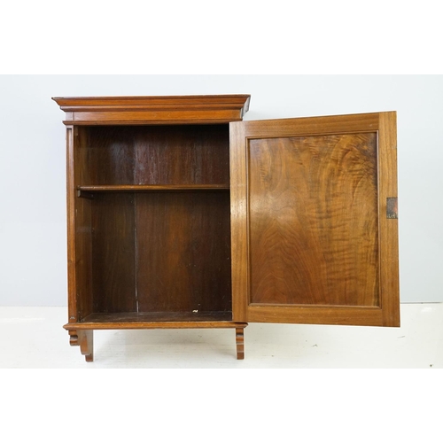 555 - 20th century mahogany hanging wall cabinet, with panelled door above carved bracket base, the interi... 