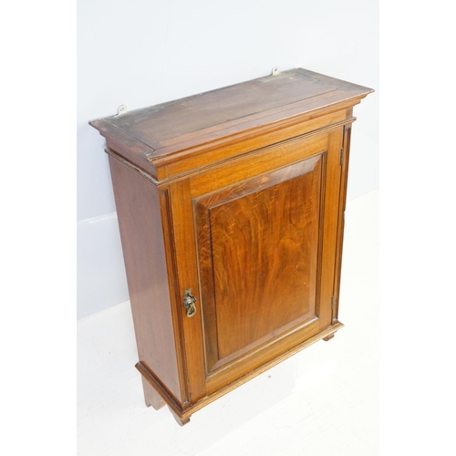 555 - 20th century mahogany hanging wall cabinet, with panelled door above carved bracket base, the interi... 