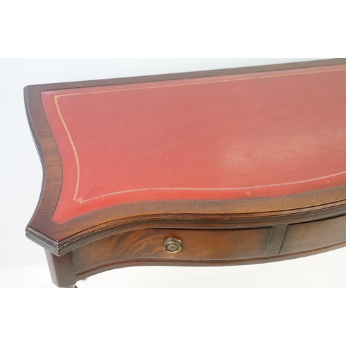 567 - 20th century mahogany games table with red leather inset top of serpentine form, top swivels to reve... 