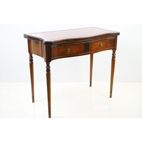 567 - 20th century mahogany games table with red leather inset top of serpentine form, top swivels to reve... 