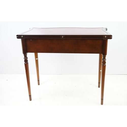 567 - 20th century mahogany games table with red leather inset top of serpentine form, top swivels to reve... 