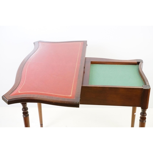 567 - 20th century mahogany games table with red leather inset top of serpentine form, top swivels to reve... 