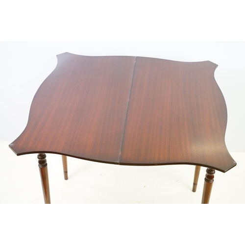 567 - 20th century mahogany games table with red leather inset top of serpentine form, top swivels to reve... 