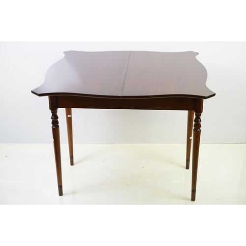 567 - 20th century mahogany games table with red leather inset top of serpentine form, top swivels to reve... 