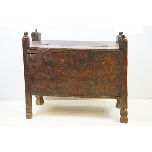 569 - 18th / 19th century Eastern coffer / blanket box, with naively carved panel front and four posts and... 