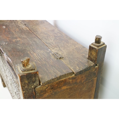 569 - 18th / 19th century Eastern coffer / blanket box, with naively carved panel front and four posts and... 