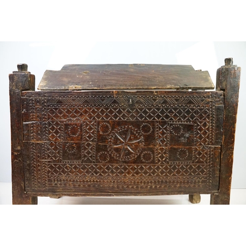 569 - 18th / 19th century Eastern coffer / blanket box, with naively carved panel front and four posts and... 