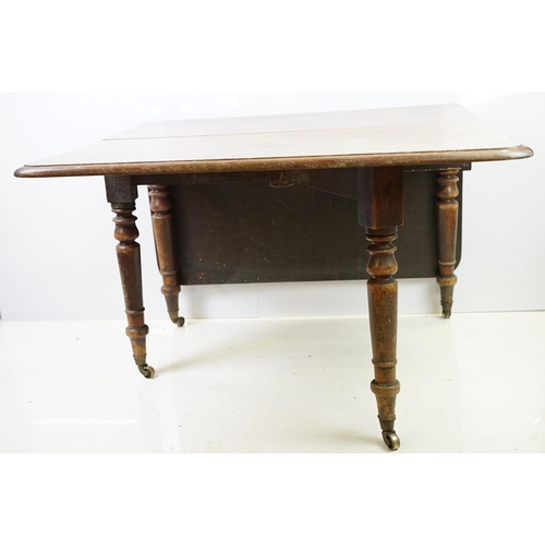 570 - 19th century mahogany drop leaf table, on turned tapering legs with brass casters, 73cm high x 161cm... 