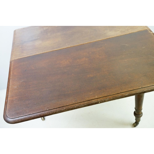 570 - 19th century mahogany drop leaf table, on turned tapering legs with brass casters, 73cm high x 161cm... 