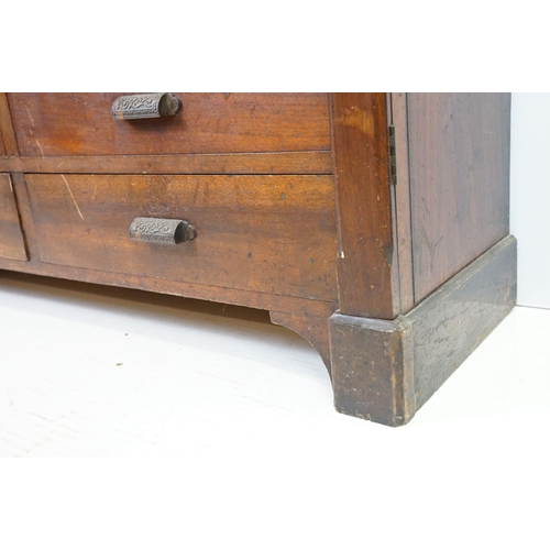 597 - Early 20th century mahogany chest of fourteen drawers, with decorative cast iron handles, with two l... 