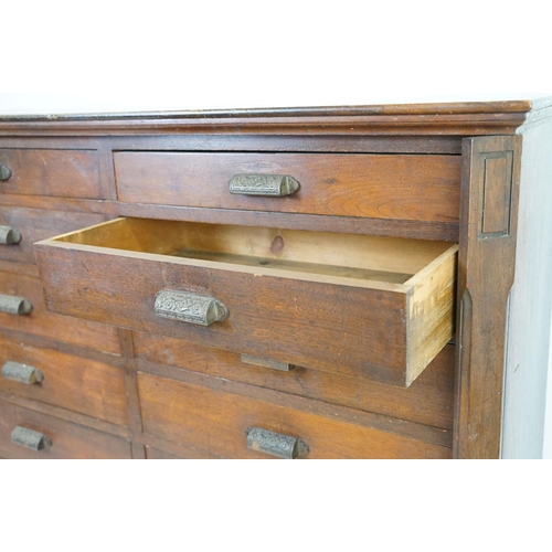 597 - Early 20th century mahogany chest of fourteen drawers, with decorative cast iron handles, with two l... 