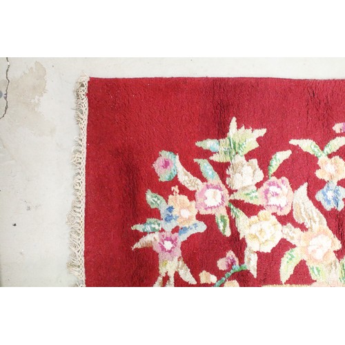 574A - Large red ground wool floor rug with floral decoration, fringe to either end, measures approx 260cm ... 