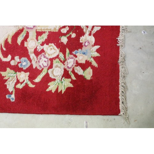 574A - Large red ground wool floor rug with floral decoration, fringe to either end, measures approx 260cm ... 