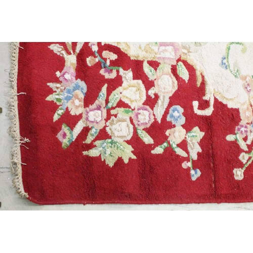 574A - Large red ground wool floor rug with floral decoration, fringe to either end, measures approx 260cm ... 