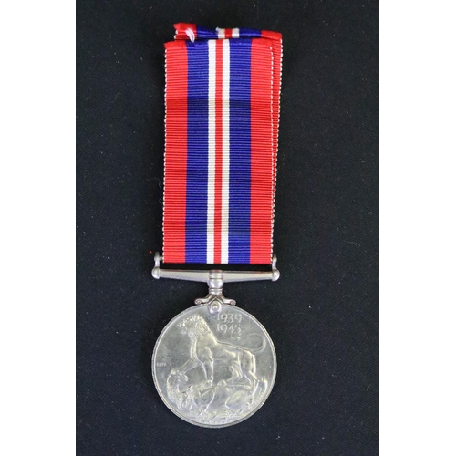 7 - A British full size World War Two medal group to include The 1939-45 British war medal, the Defence ... 