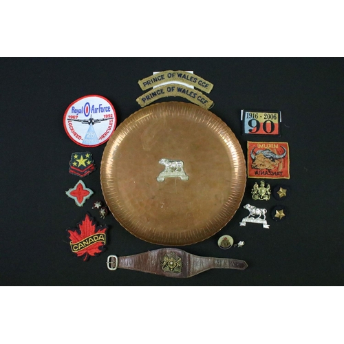 125 - A vintage hammered copper dish badged to the Kenya Regiment together with a quantity of military clo... 