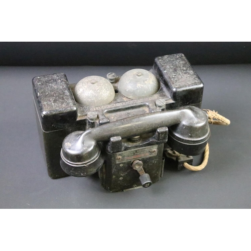 22 - A British World War Two wind up field telephone, bakelite housing stamped with the British broad arr... 