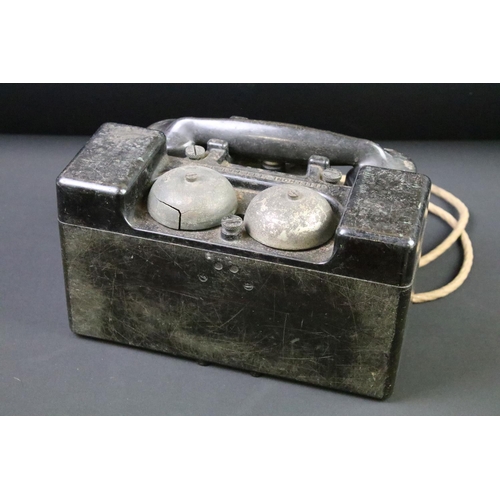 22 - A British World War Two wind up field telephone, bakelite housing stamped with the British broad arr... 