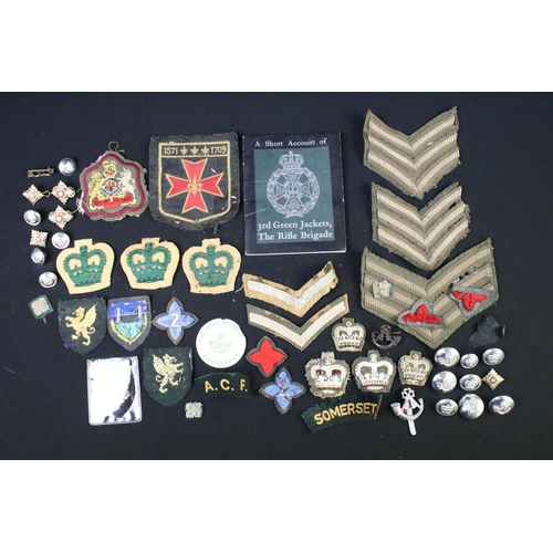 226 - A small collection of mainly British military badges, buttons and cloth patches.