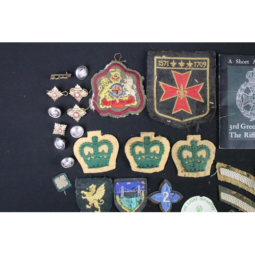 226 - A small collection of mainly British military badges, buttons and cloth patches.