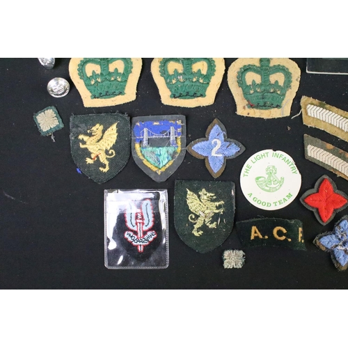 226 - A small collection of mainly British military badges, buttons and cloth patches.