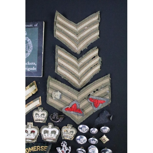 226 - A small collection of mainly British military badges, buttons and cloth patches.