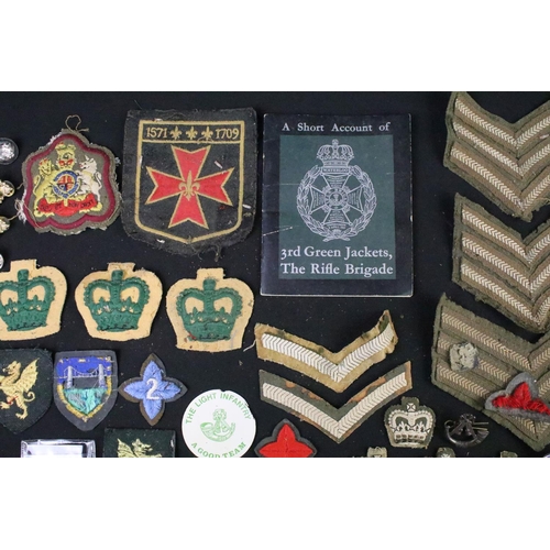 226 - A small collection of mainly British military badges, buttons and cloth patches.