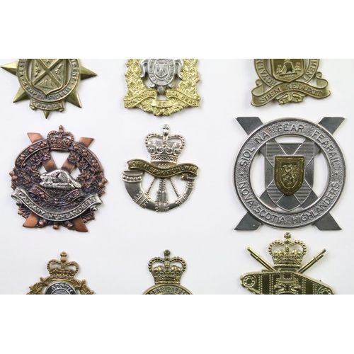 34 - A collection of Canadian Military Queens crown cap badges to include the West Nova Scotia Regiment, ... 