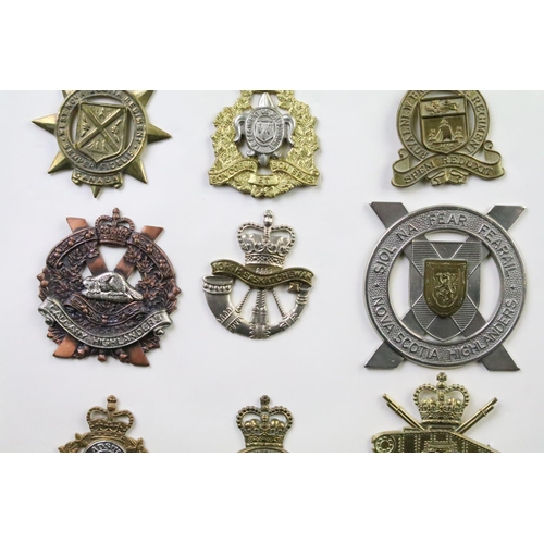 34 - A collection of Canadian Military Queens crown cap badges to include the West Nova Scotia Regiment, ... 