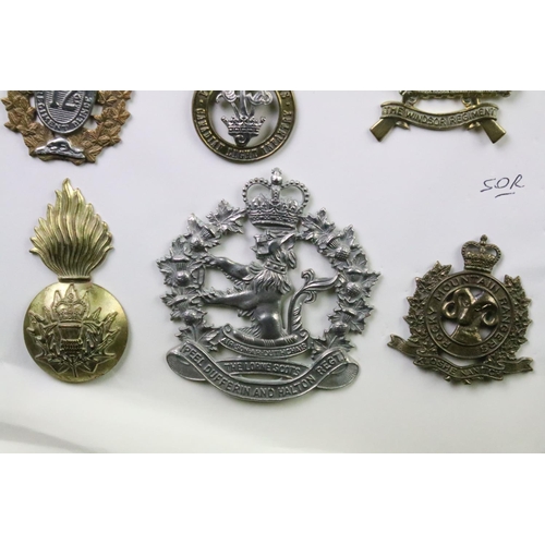 34 - A collection of Canadian Military Queens crown cap badges to include the West Nova Scotia Regiment, ... 