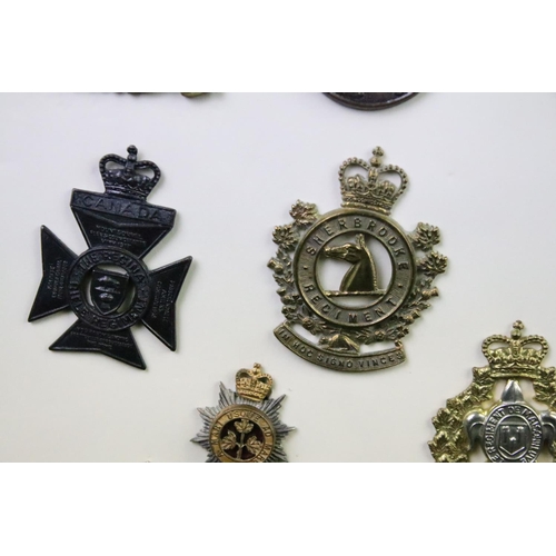 35 - A collection of Canadian Military Queens crown cap badges to include The Canadian Officers Training ... 