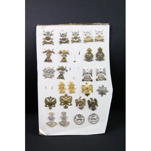 43 - A collection of British military regimental cap and collar badges to include the Devonshire regiment... 