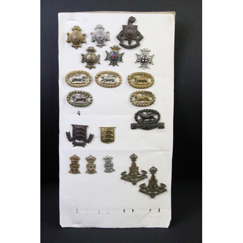 43 - A collection of British military regimental cap and collar badges to include the Devonshire regiment... 